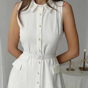 Detail of elegant sleeveless white shirt dress with pearl buttons and waist belt