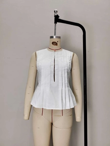 Chic white sleeveless top with textured pleats and peplum hem on a display mannequin