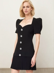 Detail of French retro black dress showing puff sleeves and shiny silver buttons