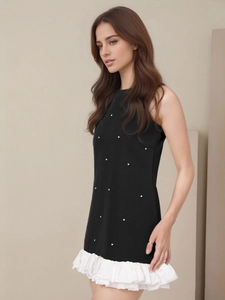 Elegant black sleeveless A-line dress with white pearl polka dots and pleated hem
