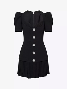 Detail of black puff sleeve dress with vertical rhinestone buttons and pleated hemline