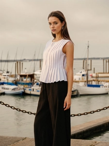Chic light purple sleeveless pleated top paired with dark brown wide-leg trousers