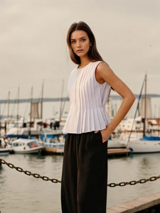 Detail of light purple pleated sleeveless top with textured fabric and chic flare hem