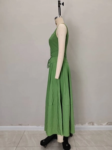 Dettaglio dell'abito lungo verde stile Hepburn con coulisse laterale in vita sul manichino