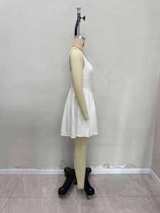 Détail d'une robe courte trapèze blanche sans manches avec boutons sur un mannequin