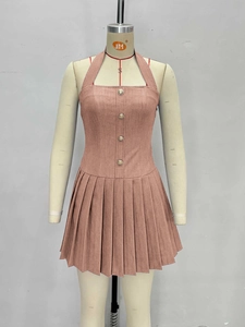 Détail de la robe dos nu rose avec jupe plissée et boutons dorés élégants