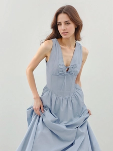 Close-up of light blue summer dress featuring V-neckline with double bow tie and corset waist