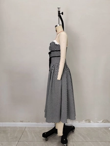Détail de robe à carreaux avec décolleté à volants et nœud à la taille sur un mannequin
