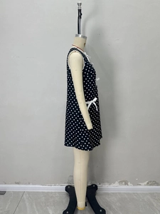 Elegant sleeveless black polka dot mini dress featuring a side bow detail and loose fit