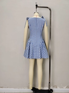Blue and white gingham dress featuring bow shoulder straps and a pleated A-line skirt