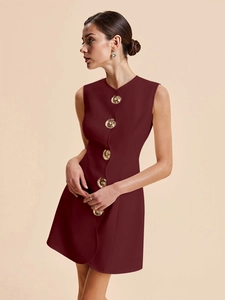 Détail de robe courte sans manches bordeaux avec boutons dorés gaufrés décoratifs