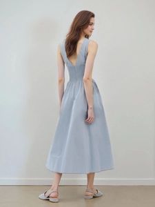 Elegant back view of light blue V-neck midi dress with smocked waist and A-line silhouette