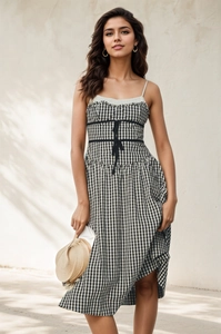 Détail d'une robe vichy style français à fines bretelles et décoration nœud à la taille