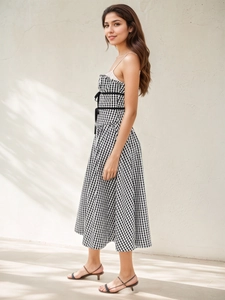 Détail de robe à carreaux française avec taille haute, nœud noir et décolleté volanté