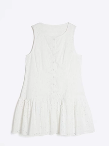 Close-up of white eyelet embroidery cotton dress featuring single-breasted buttons and ruffles