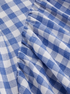Detail of blue and white gingham fabric with ruched texture on a French style summer dress