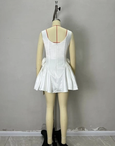 Detail of white satin dress featuring a back zipper and 3D floral bow embellishments