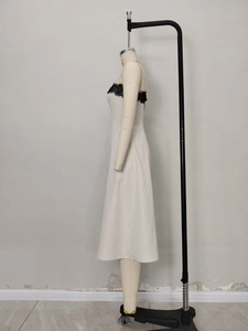 Elegante abito midi in raso bianco con pizzo nero e spalline sottili, silhouette a trapezio