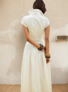 Robe blanche minimaliste à revers avec boutonnage simple et plis à la taille élégants