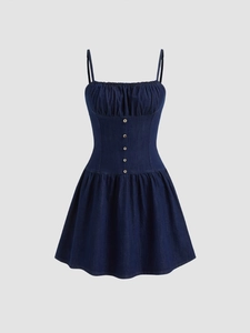 Dettaglio vestito di jeans blu scuro con spalline sottili e bottoni in metallo