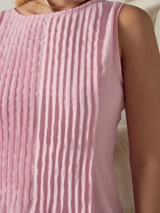 Detail of pink sleeveless dress showing elegant vertical ruching and silky fabric texture
