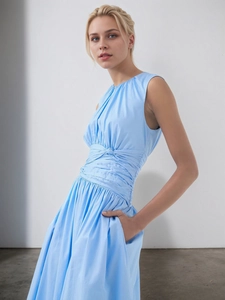 Detail view of the elegant blue dress featuring a pleated waist and a central knot design