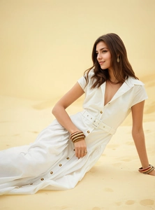 Détail de la robe blanche à revers et manches courtes avec ceinture sur fond de désert
