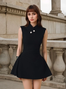 Detail of elegant black sleeveless mini dress featuring silver embossed buttons on neckline