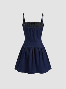 Dettaglio dell'abitino in denim blu con spalline sottili e bordo a pieghe sullo scollo