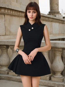 Detail of cross halter neck with sparkling rhinestone buttons on a black mini dress