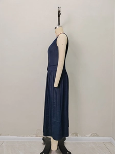 Navy blue V-neck sleeveless midi dress with waist detail and pleated skirt on a mannequin