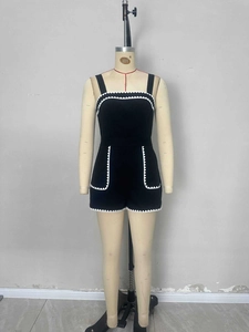 Elegante tutina corta nera con bordo in pizzo ricamato bianco e tasche laterali