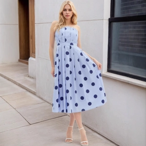 Détail d'une robe à pois bleu clair avec taille froncée et jupe plissée en ligne A