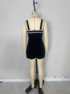 Vista posteriore dettagliata di un'elegante tutina nera da donna con pizzo bianco
