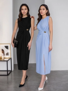 Détail d'une robe longue sans manches élégante avec plis à la taille et boucle dorée
