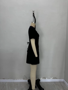 Elegant black short sleeve mini dress with lace trim and waist bow on mannequin side view