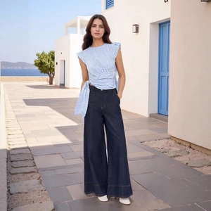 Dettaglio del top smanicato a righe blu e bianche con elegante fiocco in vita alla moda