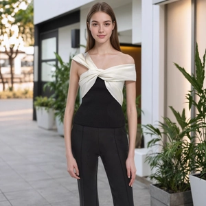 Détail du haut à épaules dénudées noir et blanc avec un nœud torsadé en satin chic