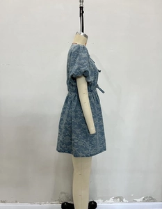 Detail of light blue denim mini dress with white floral prints and puffy bubble sleeves