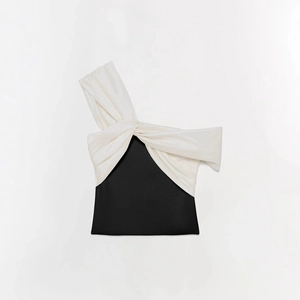 Détail d'un haut élégant contrasté noir et blanc avec design à nouer sur l'épaule dénudée