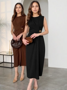 Détail de la taille froncée avec boucle dorée sur une robe longue sans manches unie