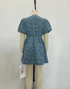 Detailed close-up of floral embroidery on blue denim puff sleeve mini dress