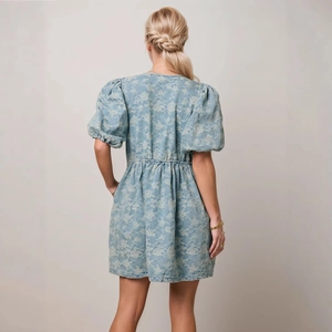 Rear view of puff sleeve denim blue dress with delicate white floral jacquard texture