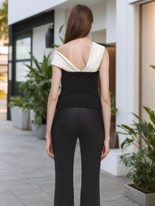 Haut contrasté noir et blanc à épaules dénudées avec pantalon noir vu de l'arrière