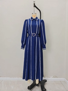 Navy long sleeve shirt dress with white polka dot stripes and a gold buckle waist belt