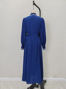 Back view of a long-sleeved dark blue maxi dress with white pearl trim and waist belt