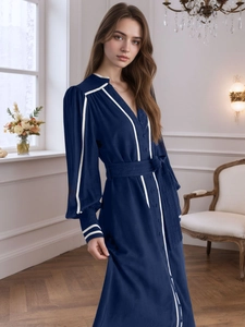 Detail eines eleganten dunkelblauen Maxikleides mit V-Ausschnitt und weißen Paspeln