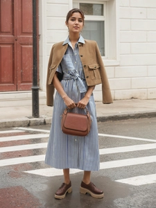 Vestido camisero de rayas azules y blancas con chaqueta de pana marrón y bolso de piel