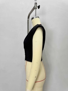 Detail view of black sleeveless top with waist-cinching and shoulder pad structure