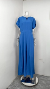 Detail view of navy blue V-neck jumpsuit with short cuffed sleeves and a high-waist design
